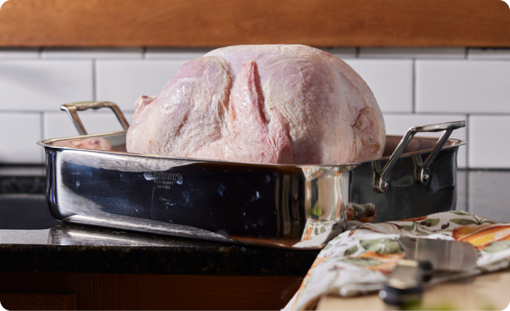 An uncooked Butterball Cook from Frozen turkey in a roasting pan.