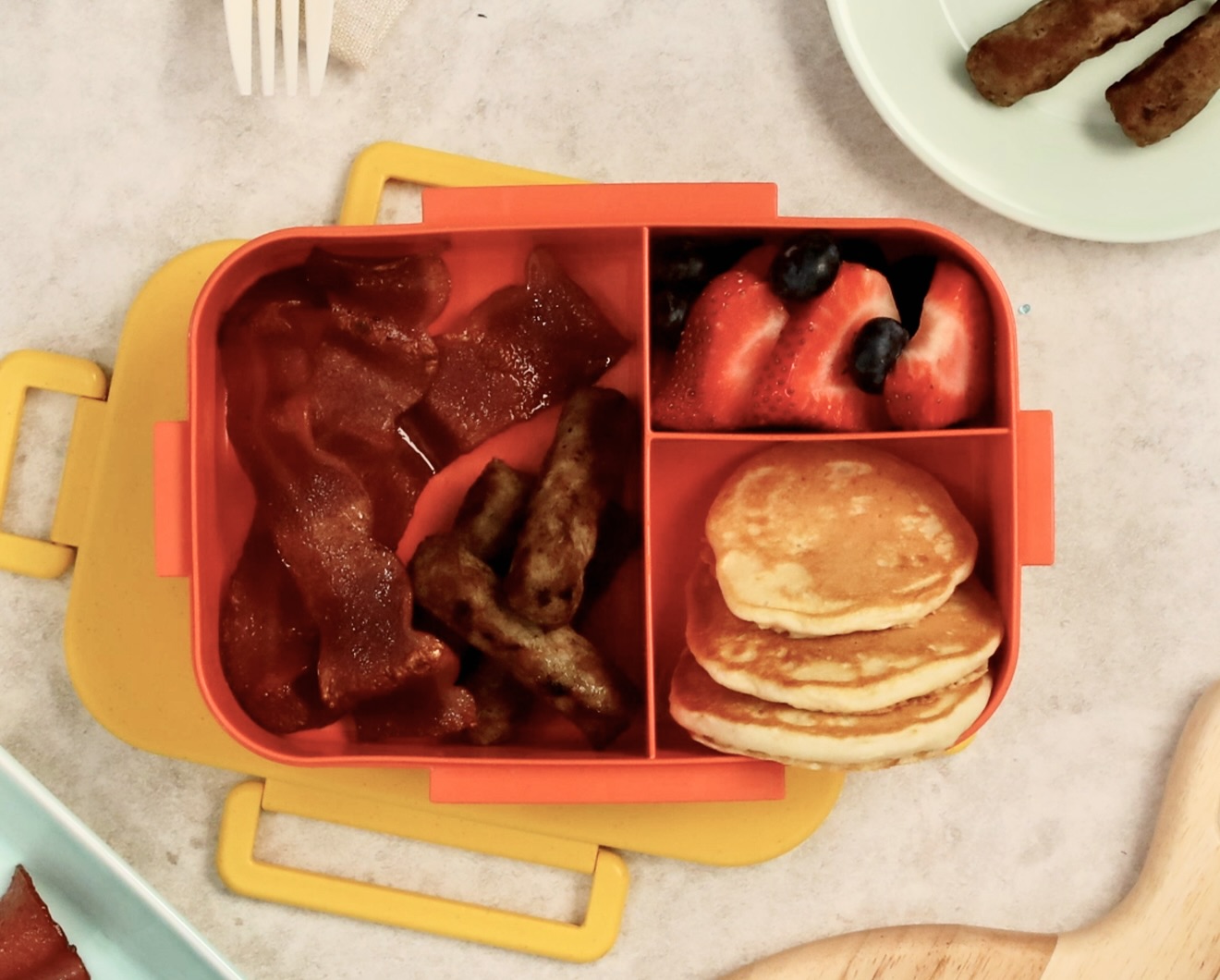 A bento box filled with breakfast foods.