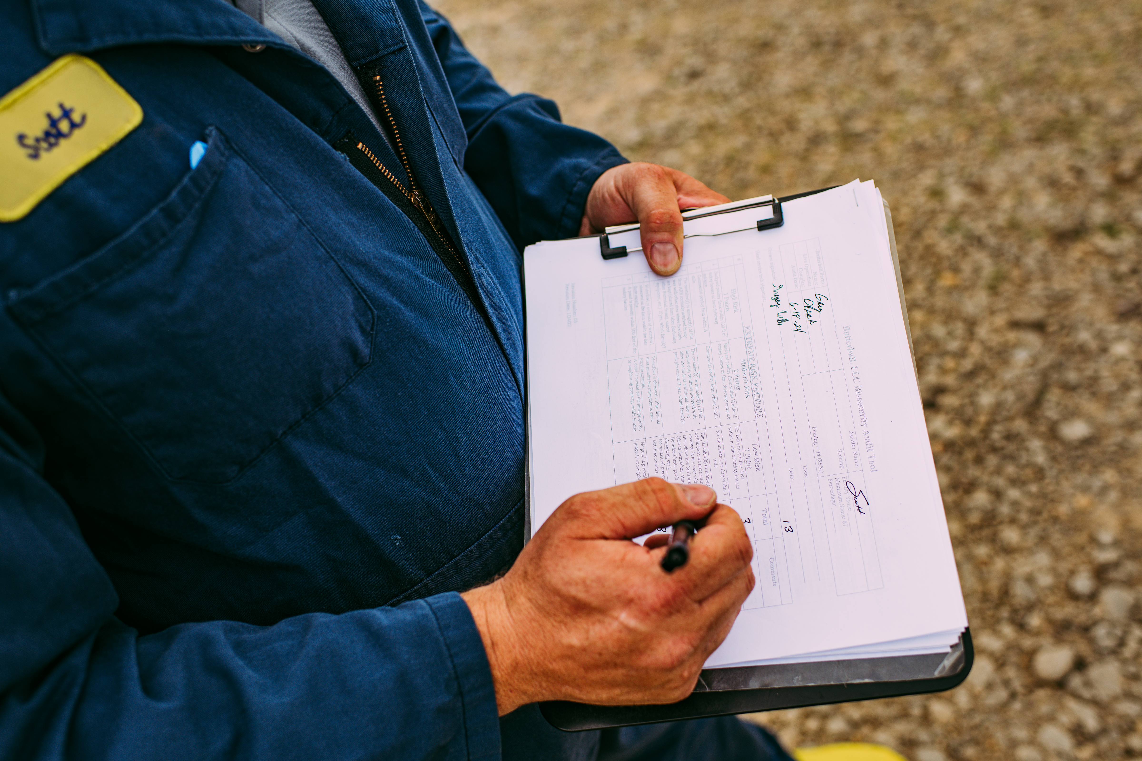 Farmer documenting animal care and well-being records on a clipboard.