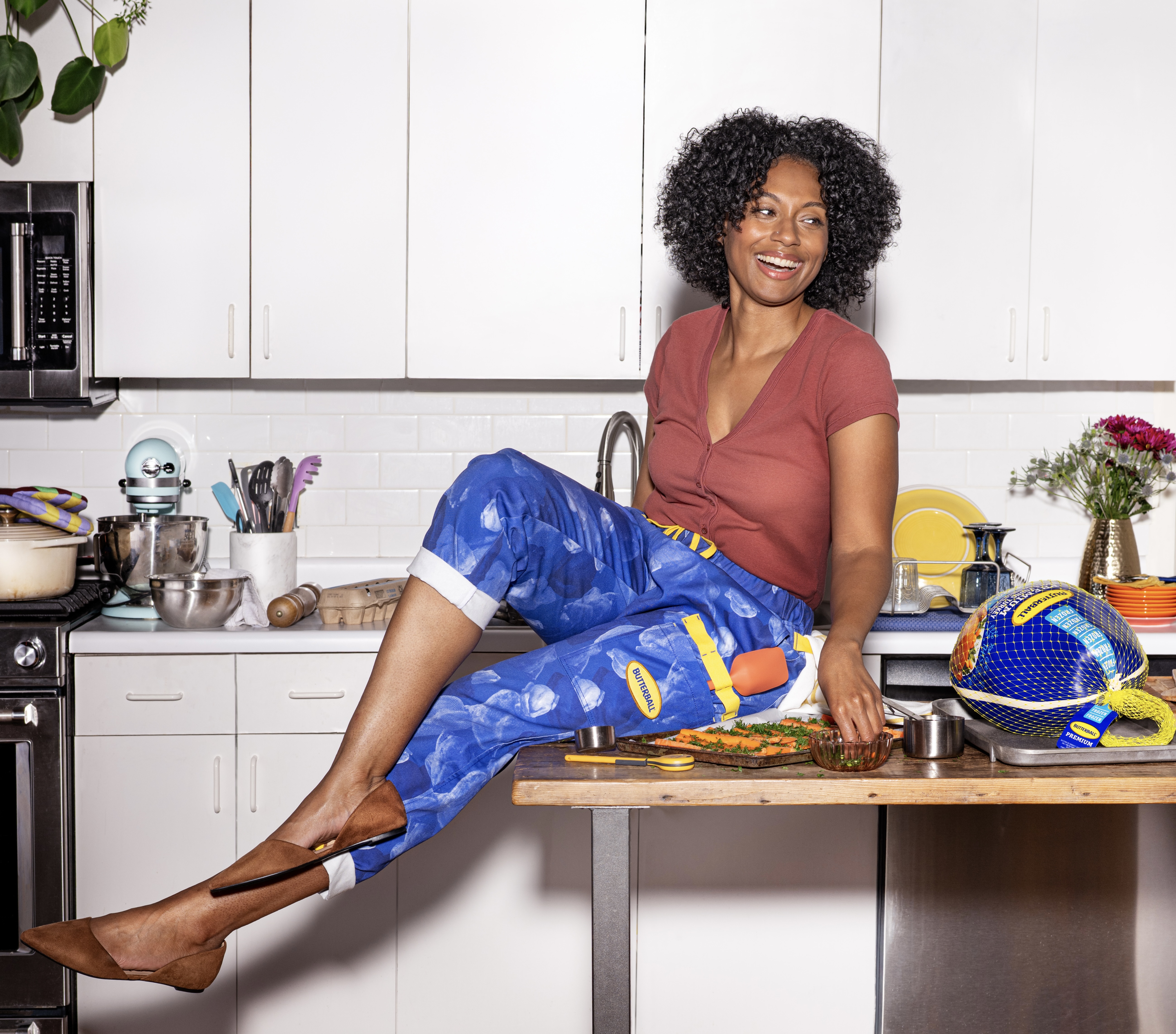 Woman wearing Butterball themed pants sitting on a table