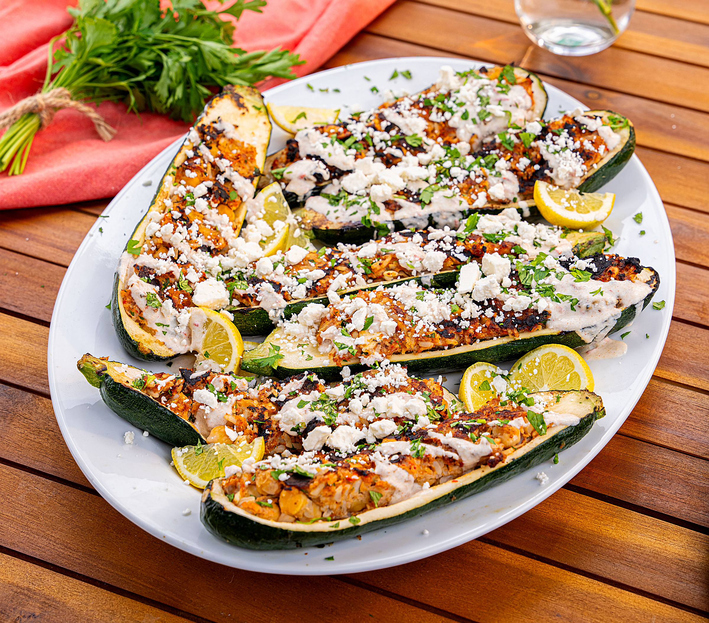 A plate of Butterball ground turkey ground turkey zucchini boats on an outdoor patio table.