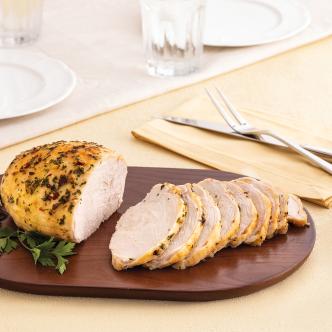 A seasoned Butterball turkey breast recipe, sliced and served on a dark wooden cutting board. 