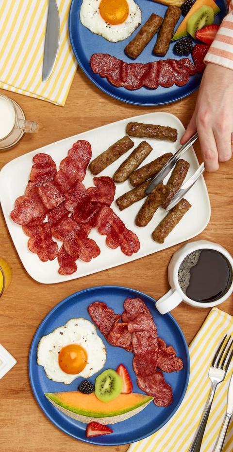 A breakfast table with Butterball sausages, turkey bacon, eggs, toast, and fruit.