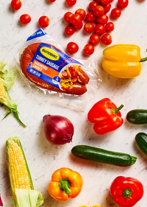Butterball Hardwood Smoked Turkey sausage on a counter next to a variety of vegetables.