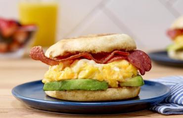 An asiago cheese, egg, and turkey bacon sandwich on an English muffin.