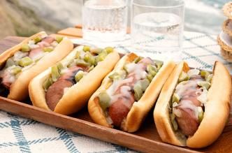 Image of Philly Cheesesteak Grilled Sausages on a tray by the beach.