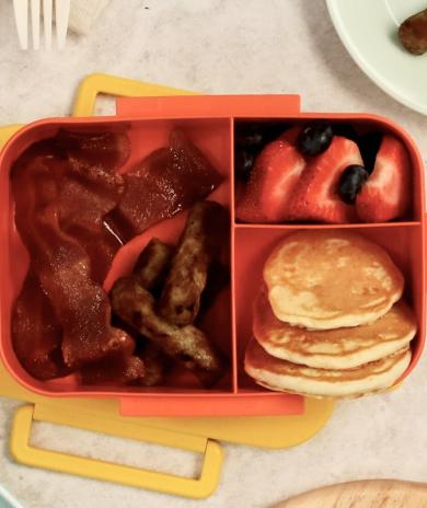 A bento box filled with breakfast foods.