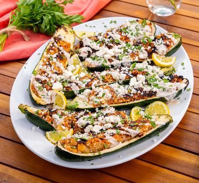 A plate of Butterball ground turkey ground turkey zucchini boats on an outdoor patio table.