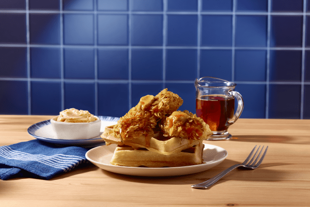 Cornflake crusted turkey tenderloin on a stack of waffles, drizzled with syrup and butter.